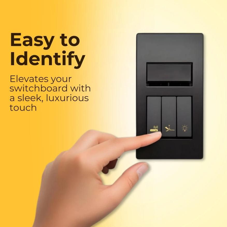 A close-up of a stylish gold decorative sticker applied to a light switch in a minimalist room setting.